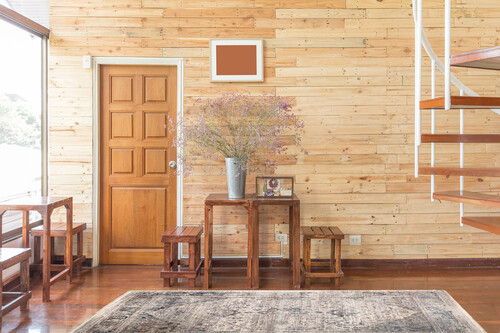 reclaimed wooden wall with wooden door table sets flowers zinc vase bright sunlight cozy warm interior atmosphere copy